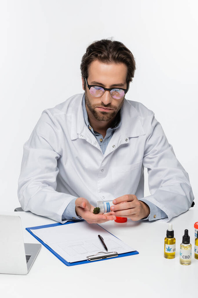 doctor sosteniendo cannabis medicinal seco cerca de la prescripción y portátil aislado en blanco - Foto, Imagen