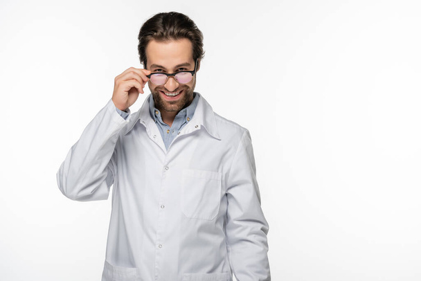 Smiling doctor holding eyeglasses isolated on white  - Zdjęcie, obraz