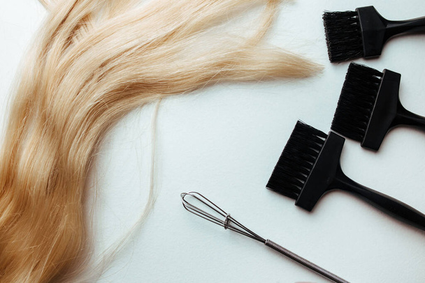 una escoba y un cepillo para teñir el cabello sobre un fondo blanco. concepto de coloración del cabello e instrumento parekmahep - Foto, imagen