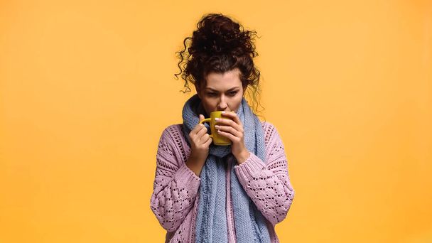 jäädytetty nainen neulottu villapaita juominen teetä eristetty oranssi - Valokuva, kuva