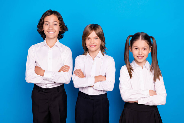 Photo of sweet adorable schoolchildren wear uniform smiling arms crossed isolated blue color background - Valokuva, kuva