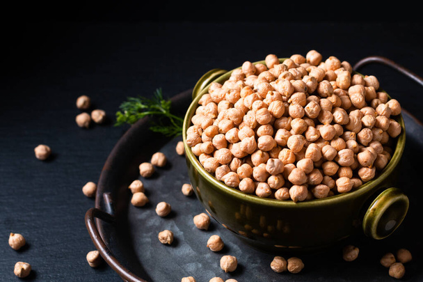 Food ingredient concept rew Chickpeas in green bowl with black background with copy space  - Photo, Image