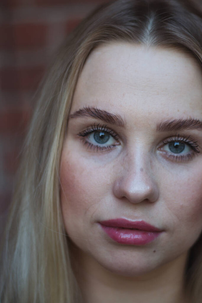 street portrait of young beautiful blonde woman with blue eyes woman close up, close-up. Natural evening light - Foto, Imagem