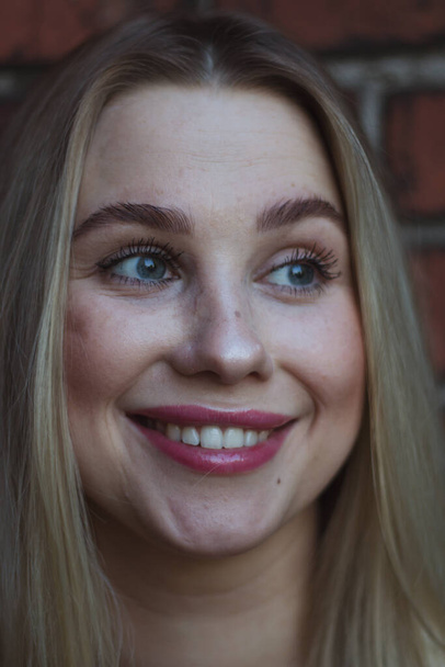 street portrait of young beautiful blonde woman with blue eyes woman close up, close-up. Natural evening light - Fotoğraf, Görsel