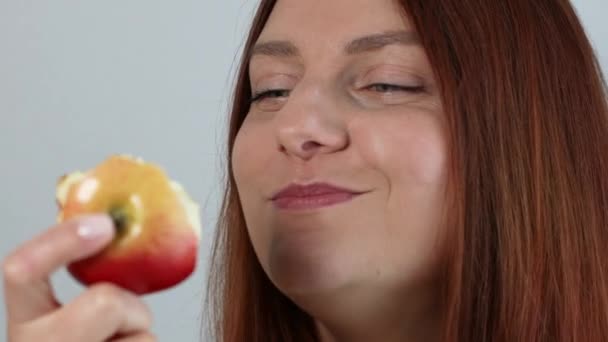 Jovencita alegre comiendo manzana roja madura, disfrutando de bocadillos orgánicos frescos, alimentación saludable y concepto de estilo de vida - Imágenes, Vídeo