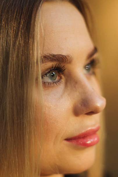 street portrait of young beautiful blonde woman with blue eyes woman close up, close-up. Natural evening light - Фото, зображення