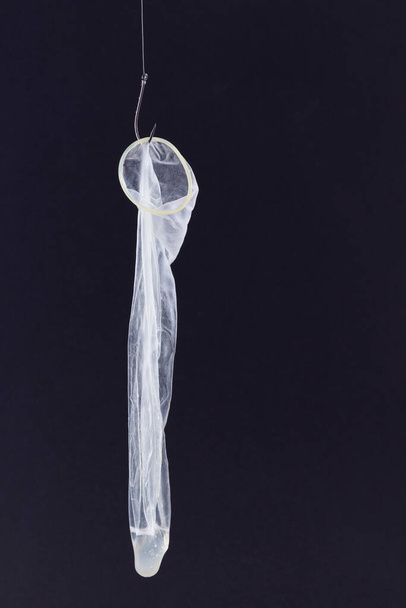 Used Condom with Sperm Inside is Hanging on a Fishing Hook - Foto, Imagem