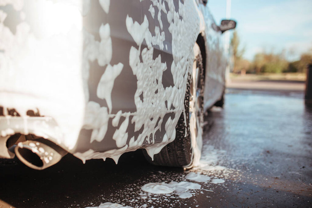 rear bumper in soapy foam. self-service car wash concept - Φωτογραφία, εικόνα