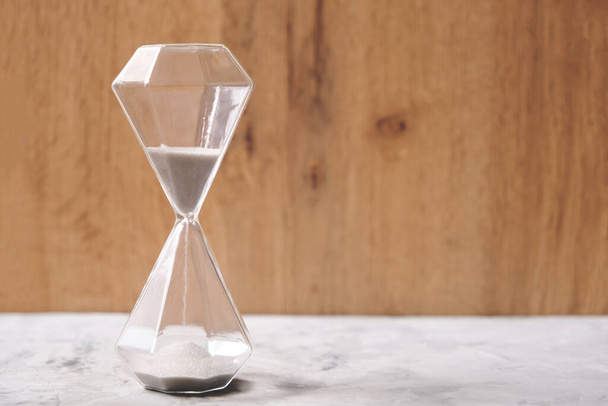 Hourglass on a wooden background, passing time - Fotoğraf, Görsel