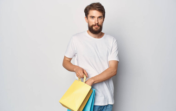 un uomo in una t-shirt bianca con i pacchetti nelle sue mani camminare stile di vita di intrattenimento - Foto, immagini