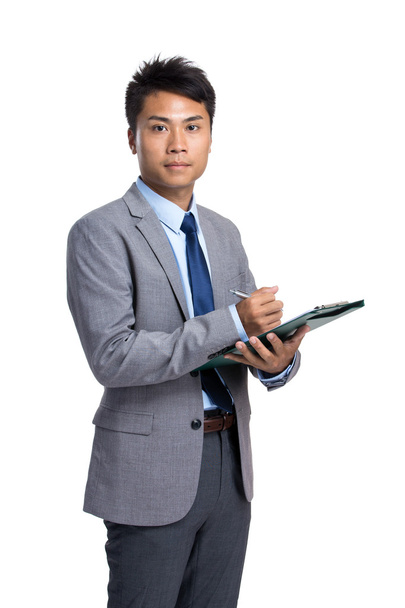 Asian businessman write on clipboard - Фото, зображення