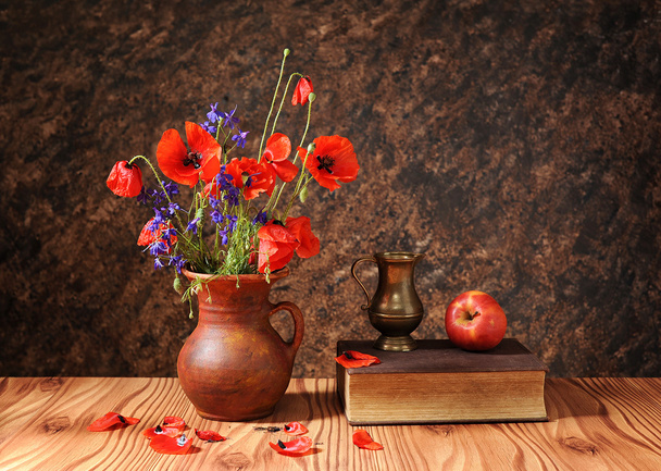 Flor de amapola en un jarrón con una manzana
 - Foto, imagen