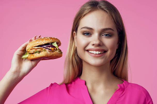 linda mujer alegre en rosa camisa hamburguesa alimentación dieta - Foto, imagen