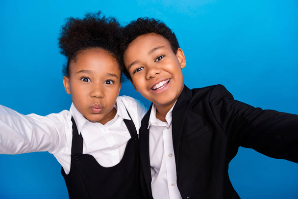 Photo of young happy positive dark skin children male selfie hug wear formalwear uniform send air kiss isolated on blue color background - Foto, Bild