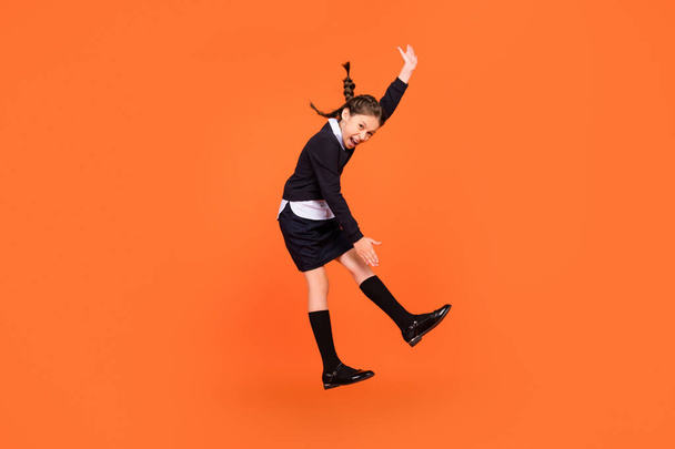 Full length body size view of trendy cheerful comic preteen girl jumping fooling dancing isolated over bright orange color background - Fotografie, Obrázek