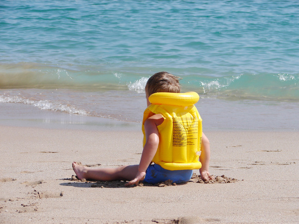a strandon a mentőmellény liitle fiú - Fotó, kép