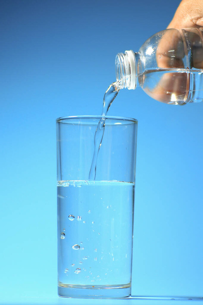 Sauberes Trinkwasser in einem Glas auf blauem Hintergrund. gesundes Trinkwasserkonzept - Foto, Bild