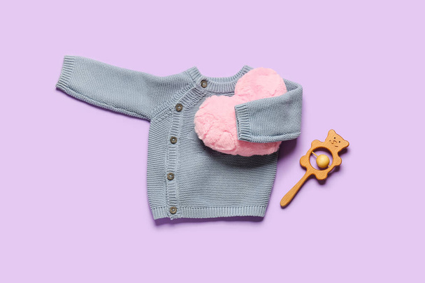 Stilvolle Babykleidung mit Spielzeug und Kissen auf farbigem Hintergrund - Foto, Bild