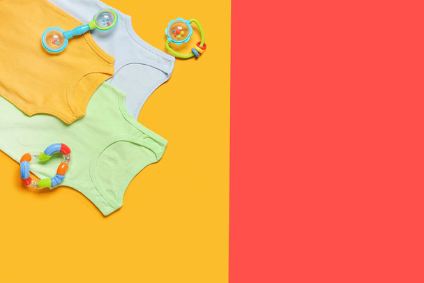 Eleganti vestiti per bambini con giocattoli sullo sfondo di colore - Foto, immagini