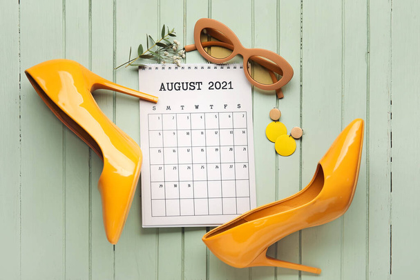 Calendario con accesorios femeninos sobre fondo de madera de color - Foto, imagen