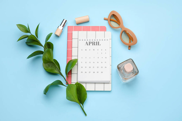 Kalender, bril, parfum en lippenstift op achtergrond van kleur - Foto, afbeelding