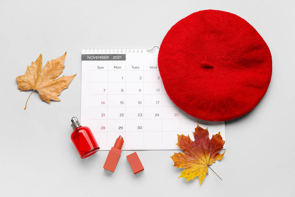 Calendario con accesorios femeninos y hojas de otoño sobre fondo claro - Foto, imagen