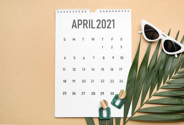 Calendario con accessori femminili e foglia tropicale su sfondo a colori - Foto, immagini
