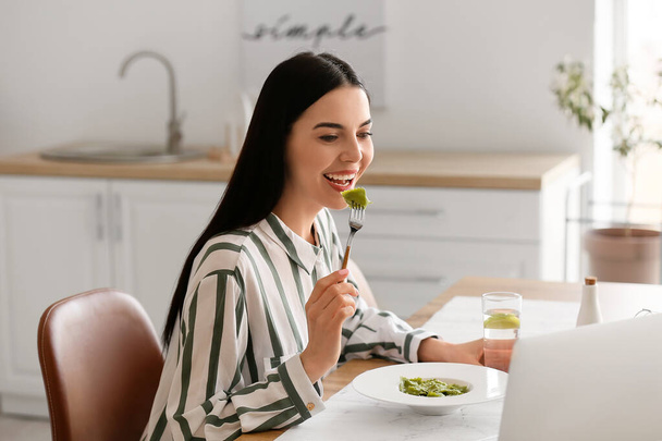 Beautiful young woman eating tasty ravioli at home - Photo, Image