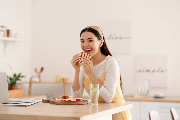 Beautiful young woman eating tasty quesadilla at home - Φωτογραφία, εικόνα