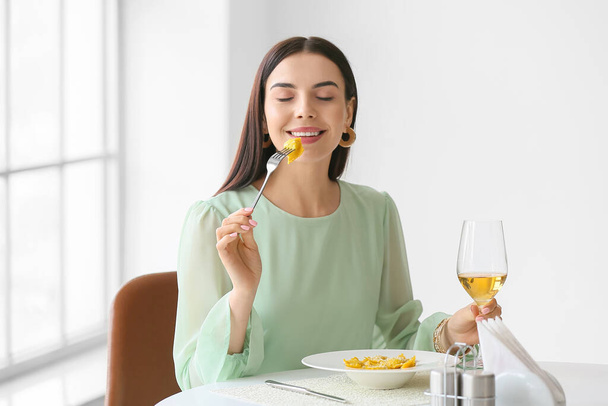 Güzel genç bir kadın kafede lezzetli ravioli yiyor. - Fotoğraf, Görsel
