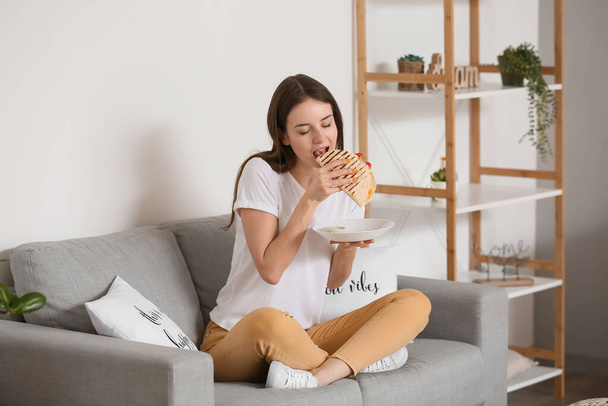 Krásná mladá žena jíst chutné quesadilla doma - Fotografie, Obrázek