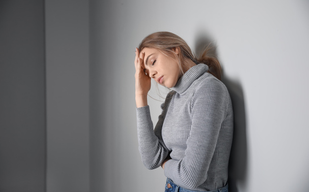 Депресивна молода жінка на сірому фоні
 - Фото, зображення