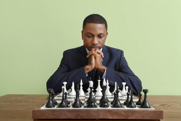 African-American man playing chess at table - Foto, afbeelding