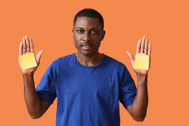 Afroamerykanin z pustymi kartkami papieru na tle koloru - Zdjęcie, obraz