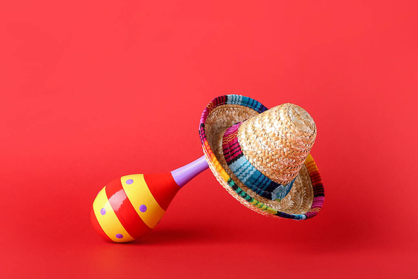 Mexican maraca and sombrero on color background - Photo, Image