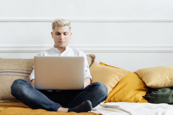 Remote Job. Man Working On Laptop Sitting On Sofa At Home - Foto, imagen