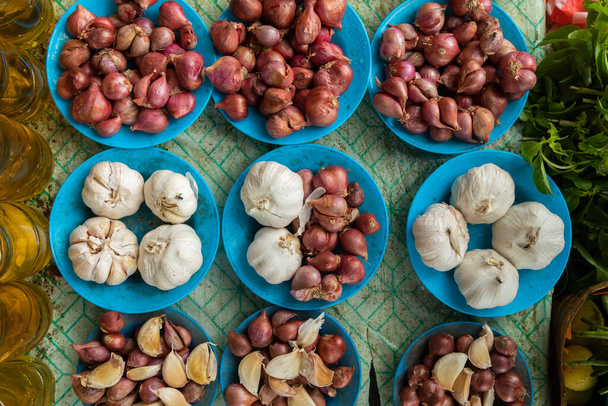 Dziesiątki czosnku i cebuli, na sprzedaż w budce spożywczej, na lokalnym rynku w Waisai, Raja Ampat, Indonezja - Zdjęcie, obraz