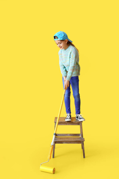 Little girl with paint roller on color background - Fotografie, Obrázek