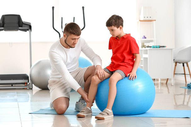 Fisioterapeuta trabajando con un niño en un centro de rehabilitación - Foto, imagen