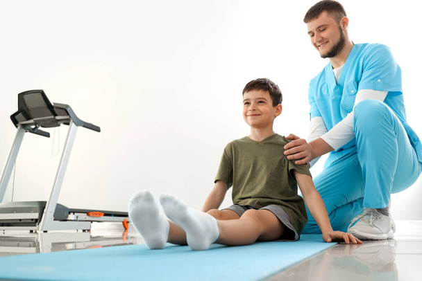 Fyzioterapeut pracující s chlapcem v rehabilitačním centru - Fotografie, Obrázek