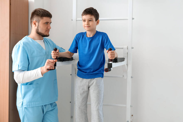 Physiothérapeute travaillant avec un garçon dans un centre de réadaptation - Photo, image