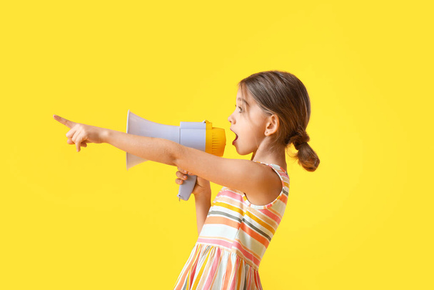 Cute little girl with megaphone on color background - Foto, imagen