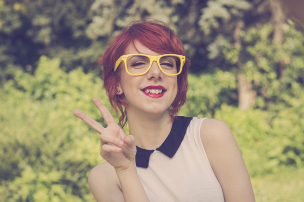 Cute hipster girl showing peace sign with her hand - Photo, Image