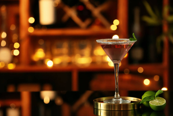Copa de sabroso cóctel cosmopolita y lima en la mesa en el bar - Foto, imagen