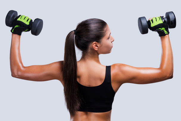 Sporty woman exercising with dumbbells - Zdjęcie, obraz