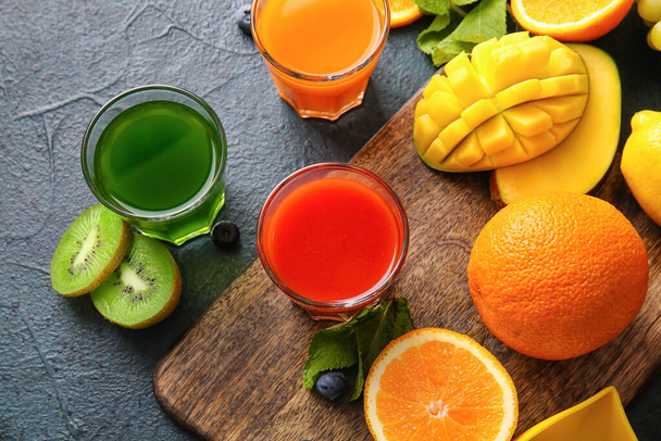 Bicchieri con succo sano, frutta e verdura su sfondo scuro - Foto, immagini