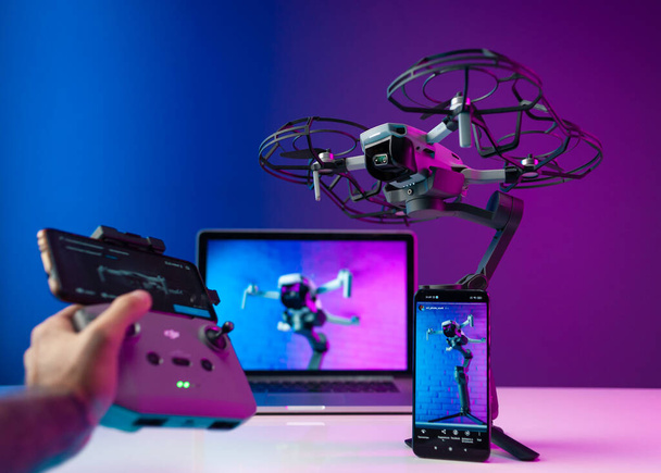 Belgorod Russia July 28, 2021, DJI Mini 2 unmanned aerial vehicle with propeller and camera protection, stands on the stabilizer of dji osmo mobile 3 with a laptop and a mobile phone - Fotó, kép
