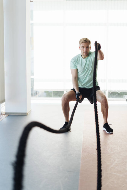 Young athlete man is training with rope in a space with a lot of light - Fotoğraf, Görsel
