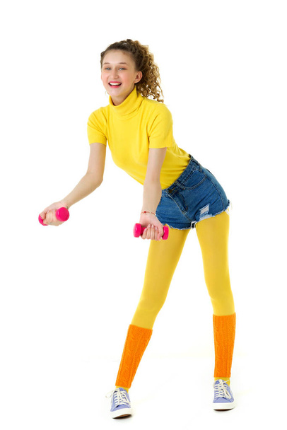 Happy slim girl doing aerobics with red dumbbells - Fotografie, Obrázek