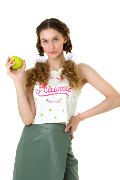 Pretty teen girl in fashion outfit eating apple - Zdjęcie, obraz